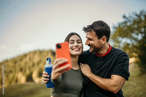 Fototapeta Naklejka Na Ścianę i Meble -  Woman and man from different backgrounds pose for a selfie post-workout