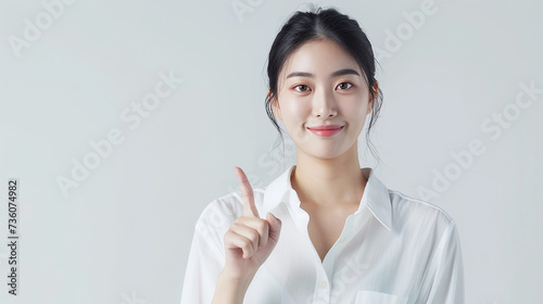  Retrato de estúdio de uma mulher chinêsa confiante posando sobre um fundo amarelo colorido brilhante, piscando e segurando o polegar para cima,