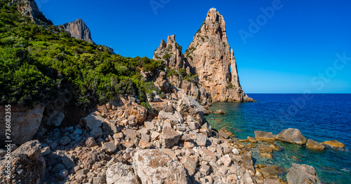 Panoramic view of “Pedra Longa“ on the island of Sardinia, Italy. Natural landmark and tourist attraction on the cliff coast of mediterranean sea near Baunei in the Gulf of Orosei. Sunny holiday spot. photo