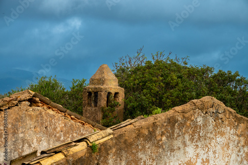 The traditional Algarvian chimney (Chaminé Algarvia) among the ruins of an old farm house, Algarve, Portugal photo