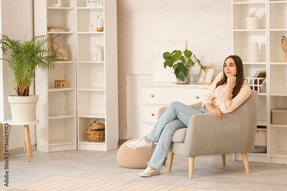 Beautiful woman sitting in armchair at home Beautiful woman sitting in armchair at home