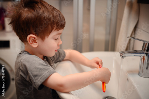 Young Child Practicing Oral Hygiene by Brushing Teeth at Sink