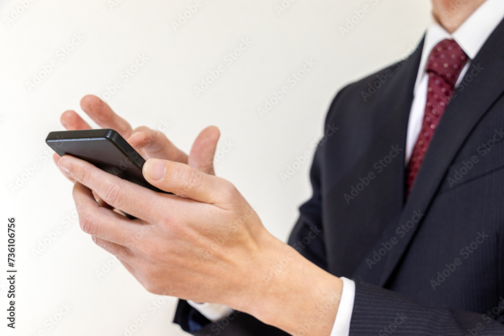 スマートフォンを使うスーツ姿の男性 スマートフォンを使うスーツ姿の男性