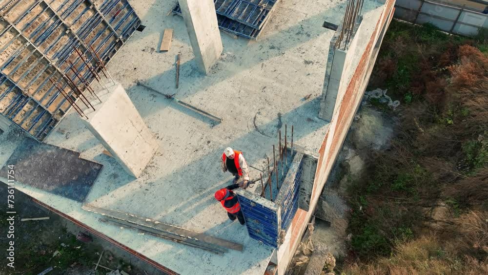 Aerial view Construction Workers on Building Site, Aerial view of construction workers collaborating on a concrete structure at a building site.