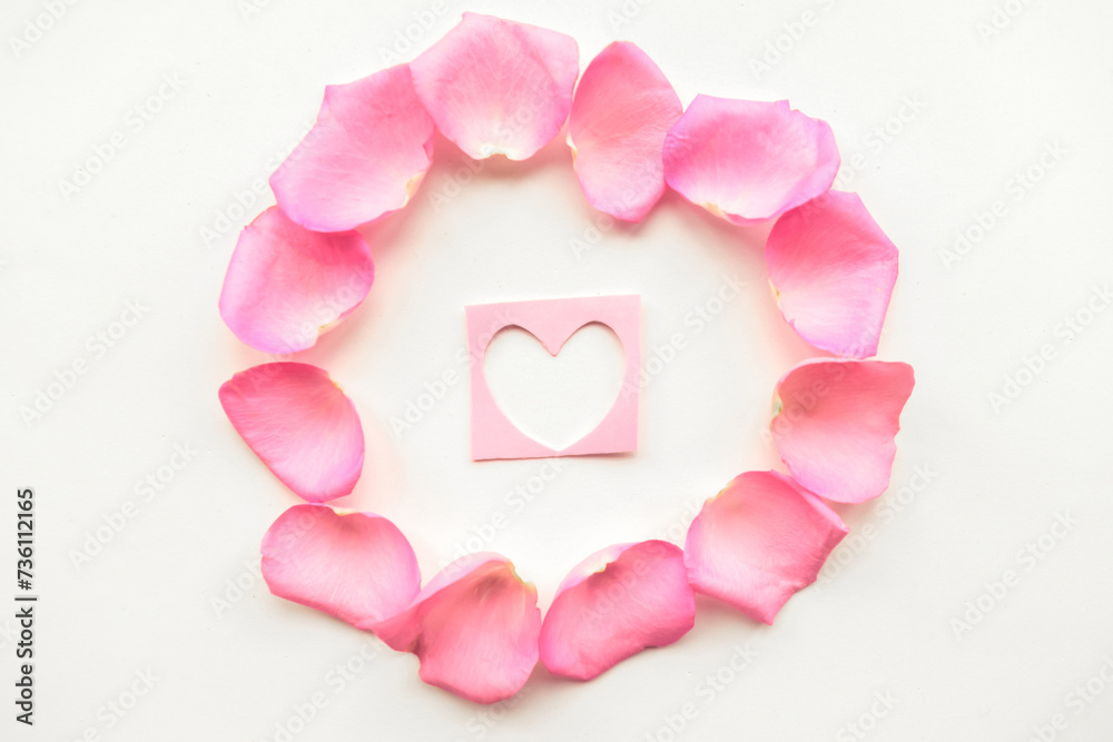 Love composition - figure of heart in the center of a pink petals frame
