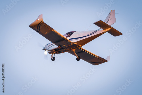 Small plane flying with sunset light in a blue sky. Light plane.