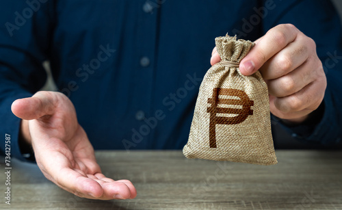 Giving gesture and philippine peso money bag. Banking and crediting. The man offers a deal in return. Salary benefits. Attracting investments. Mortgage, loan approval. Deposit savings. Cashback. photo