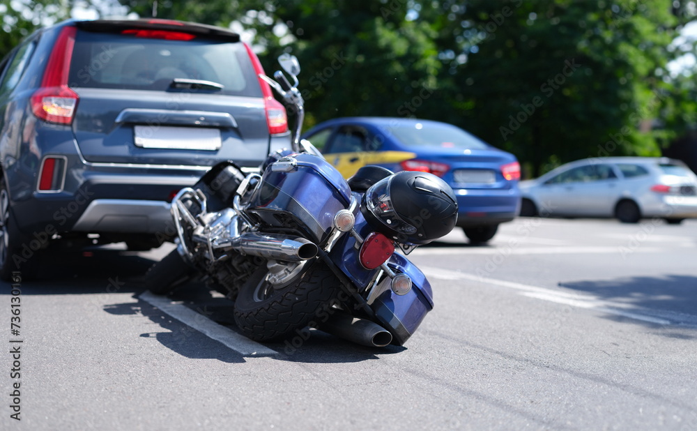 Blue motorcycle lying on road near car closeup. Road traffic accidents with motorcyclists concept Blue motorcycle lying on road near car closeup. Road traffic accidents with motorcyclists concept