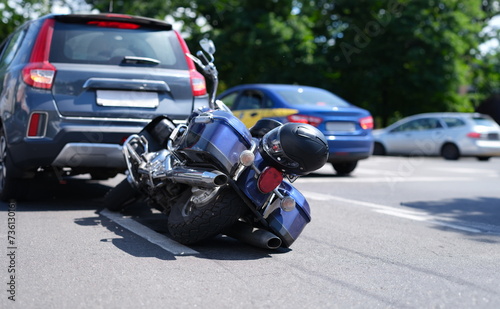 Blue motorcycle lying on road near car closeup. Road traffic accidents with motorcyclists concept © H_Ko