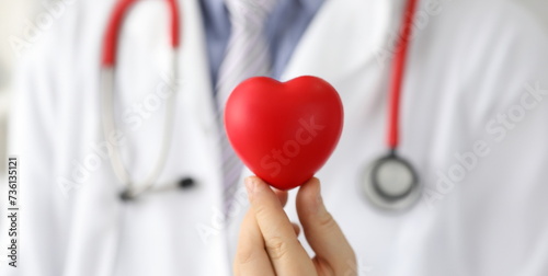 Doctor holds mock heart with black dot, pacemaker. Reduce risks heart disease. Get advice from specialist doctor. Preparation for diagnostic study heart. Providing high-tech medical care