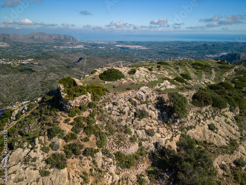 Aerial view of Castell d'Aixa and Castell de la Solana mountain ridge in a sunny blue sky, Lliber, Costa Blanca, Alicante, Spain - stock Photo photo