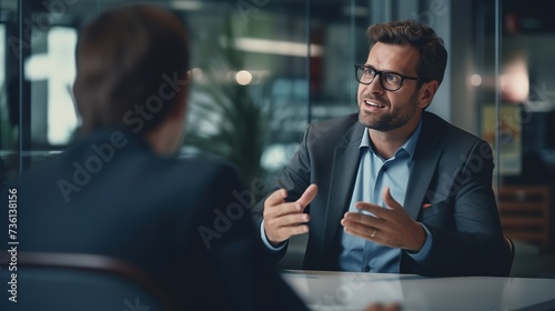 Smart businessman professional man in suit executive gesturing and talking in meeting with interview employee about work in modern office. copy space for text.
