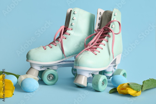 Vintage roller skates with Easter eggs and beautiful tulips on blue background