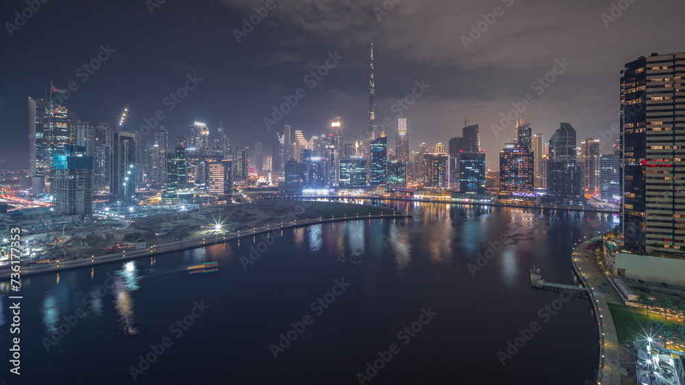 Obraz premium Aerial view to Dubai Business Bay and Downtown with the various skyscrapers and towers day to night timelapse
