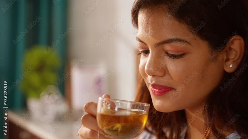 close up headshot of Indian Woman drinking Green tea after waking up during morning at bedroom - concept of herbal detox, morning rituals and mindfulness. close up headshot of Indian Woman drinking Green tea after waking up during morning at bedroom - concept of herbal detox, morning rituals and mindfulness.