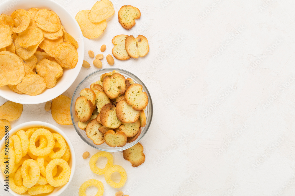 Various unhealthy snacks on concrete background, top view