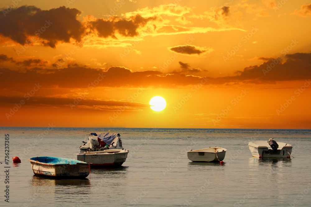 Fishing boats on the sea and the incredible sky. Amazing sunset.