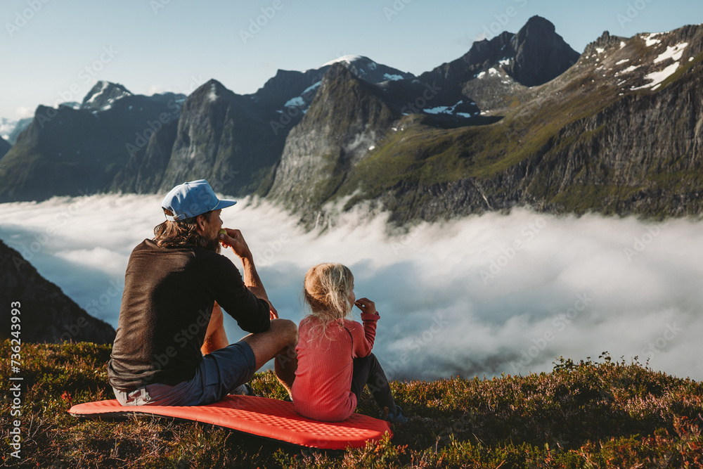 Family picnic father and daughter eating snacks in mountains travel vacations camping outdoor dad with child hiking together active lifestyle adventure trip parent and kid enjoying views in Norway - obrazy, fototapety, plakaty 