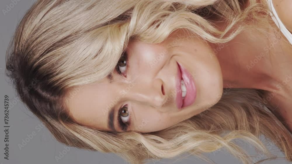 Studio portrait of young and beautiful blond woman over grey background. Skin care and wellness concepts. Studio portrait of young and beautiful blond woman over grey background. Skin care and wellness concepts.