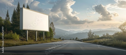 Scenic rural road with a blank billboard for outdoor advertising in a picturesque countryside photo