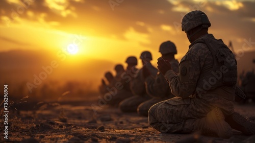 Military man praying outdoors on knees.