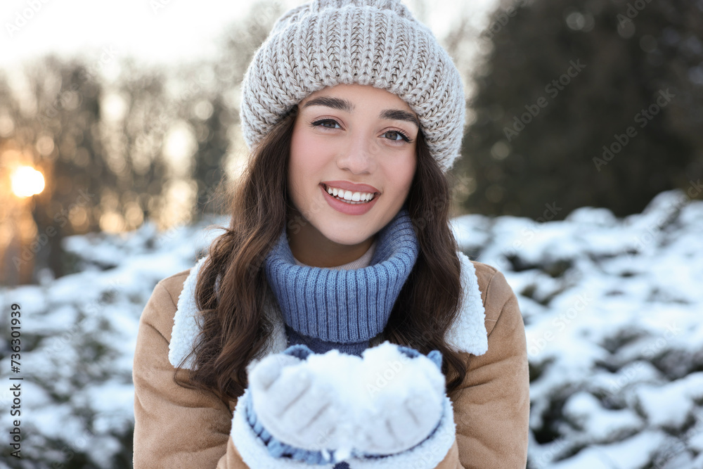 Portrait of smiling woman holding pile of snow in park Portrait of smiling woman holding pile of snow in park