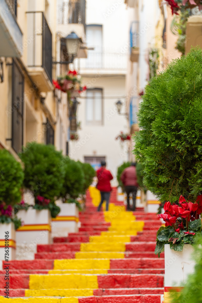 Stairs in the old quarter of Calpe painted with red and yellow colors.
