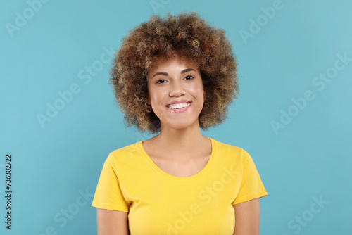 Woman with clean teeth smiling on light blue background
