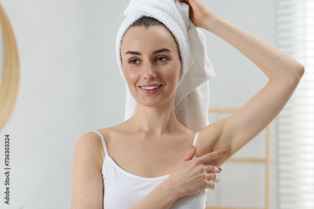 Beautiful woman showing armpit with smooth clean skin in bathroom Beautiful woman showing armpit with smooth clean skin in bathroom