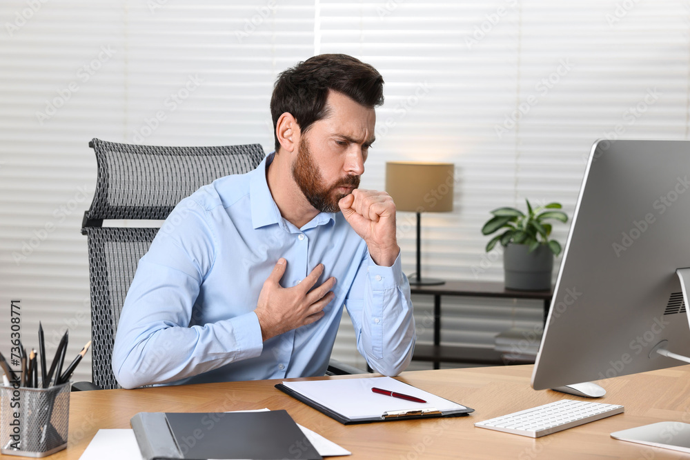 Sick man coughing at workplace in office. Cold symptoms Sick man coughing at workplace in office. Cold symptoms