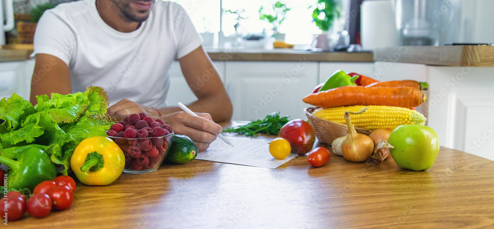 A nutritionist writes a nutrition plan. Selective focus. A nutritionist writes a nutrition plan. Selective focus.