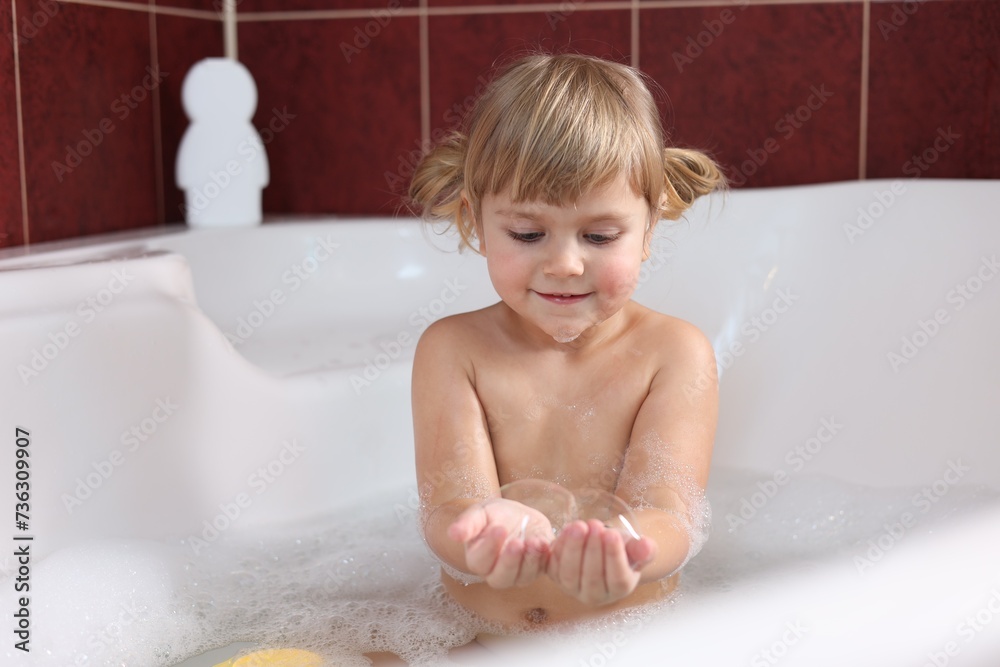 Little girl having fun in bathtub at home Little girl having fun in bathtub at home