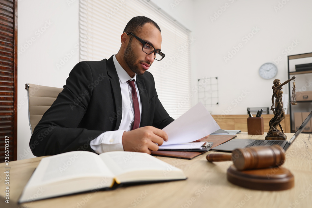 Confident lawyer working with document at table in office Confident lawyer working with document at table in office