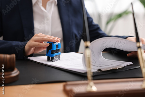 Foto Notary stamping document at table in office, closeup