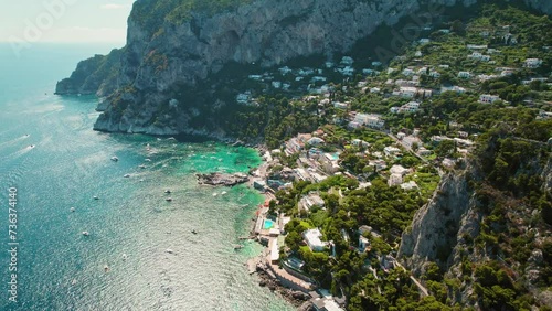 Aerial view of Capri Island with rugged coastline and azure Tyrrhenian Sea in summer Italy. Popular tourist attraction. photo
