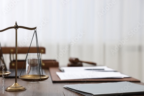 Lawyer's workplace. Scales of justice, folder and documents on wooden table indoors, space for text