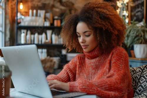 Young business woman teleworking and using a laptop on a table at home to search for information, perform tasks, shop online, etc....