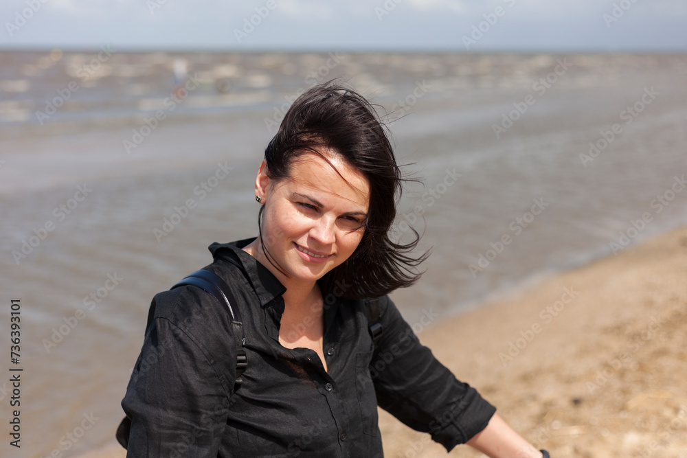 Portrait of a beautiful young woman on the beach in summer.