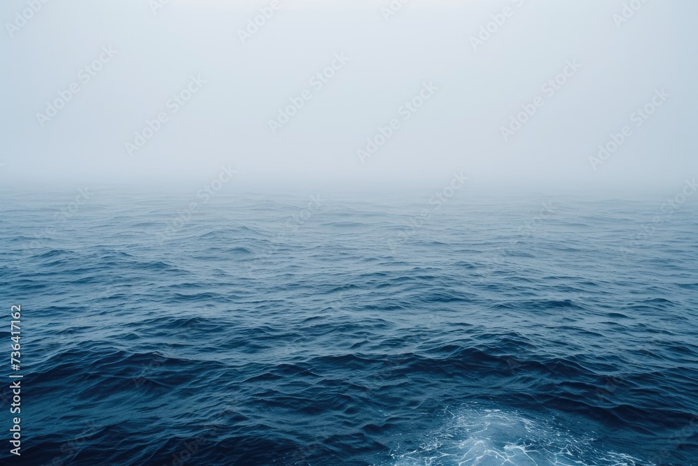 Aerial photograph capturing a wide expanse of water beneath a fog-covered sky, Atmospheric representation of a foggy ocean with barely visible waves, AI Generated