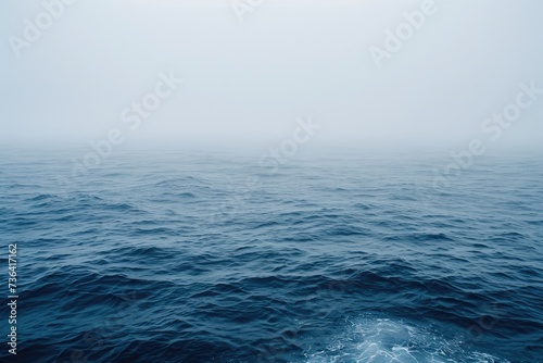 Aerial photograph capturing a wide expanse of water beneath a fog-covered sky, Atmospheric representation of a foggy ocean with barely visible waves, AI Generated