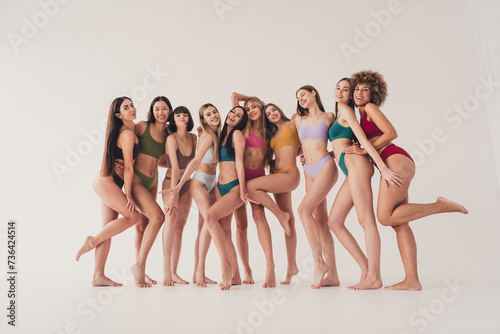No retouch photo of cute ten sisters in underwear posing bare feet and smiling isolated over white color background
