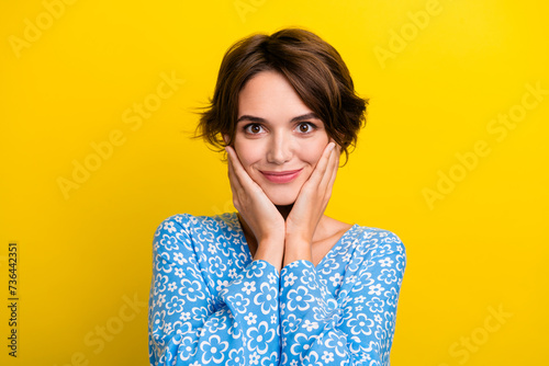Photo of dreamy pretty woman wear flower print blouse smiling arms cheeks isolated yellow color background © deagreez