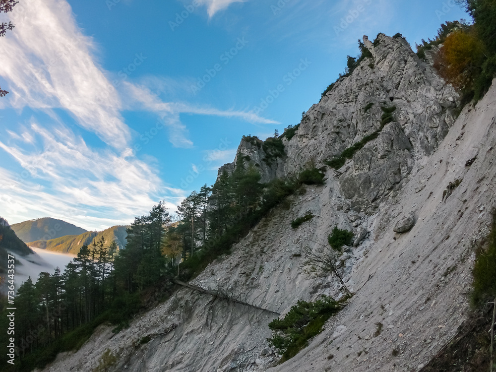 Scenic view of fog covered valley in Hochschwab mountain range, Styria, Austria. Hiking trail in alpine forest. Remote Austrian Alps in summer. Escapism. Connect with nature