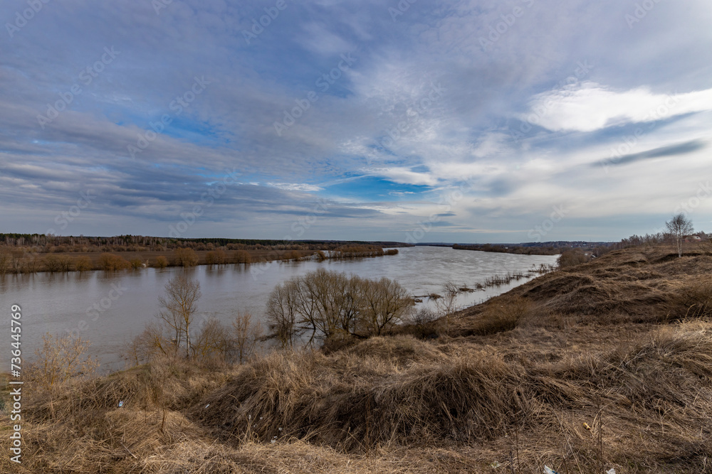 early spring flood, high water in the countryside, river overflowing its banks, trees in the water, flooded banks, environmental pollution, ecology