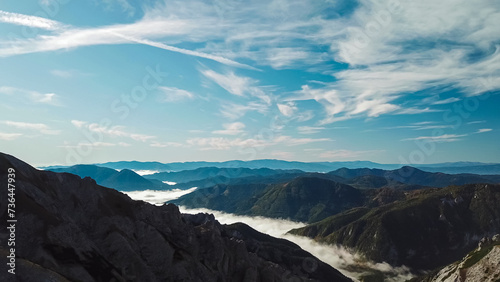 Scenic view of fog covered valley in Hochschwab mountain range, Styria, Austria. Hiking trail in alpine forest. Remote Austrian Alps in summer. Escapism. Connect with nature