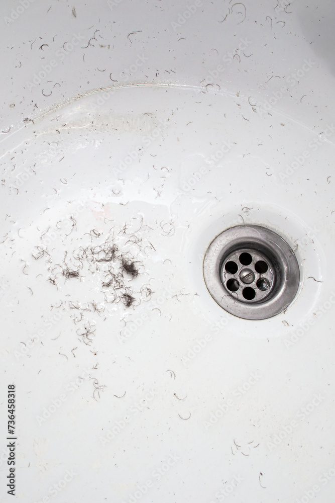 shaved hair from the intimate areas of the pubic area after shaving and depilation remaining on the walls of the bathroom sink, close-up texture shaved hair from the intimate areas of the pubic area after shaving and depilation remaining on the walls of the bathroom sink, close-up texture
