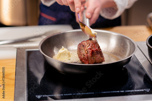 close-up of seared beef steak with rosemary topped with melted butter in frying pan