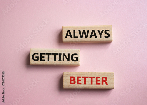 Always getting better symbol. Wooden blocks with words Always getting better. Beautiful pink background. Business and Always getting better concept. Copy space.