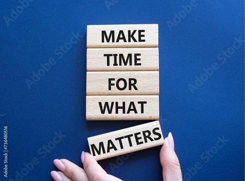 Important thing symbol. Wooden blocks with words Make time for what matters. Businessman hand. Beautiful deep blue background. Business and important thing concept. Copy space. photo