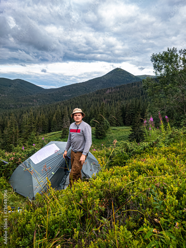 A tourist looks at the camera near his tent